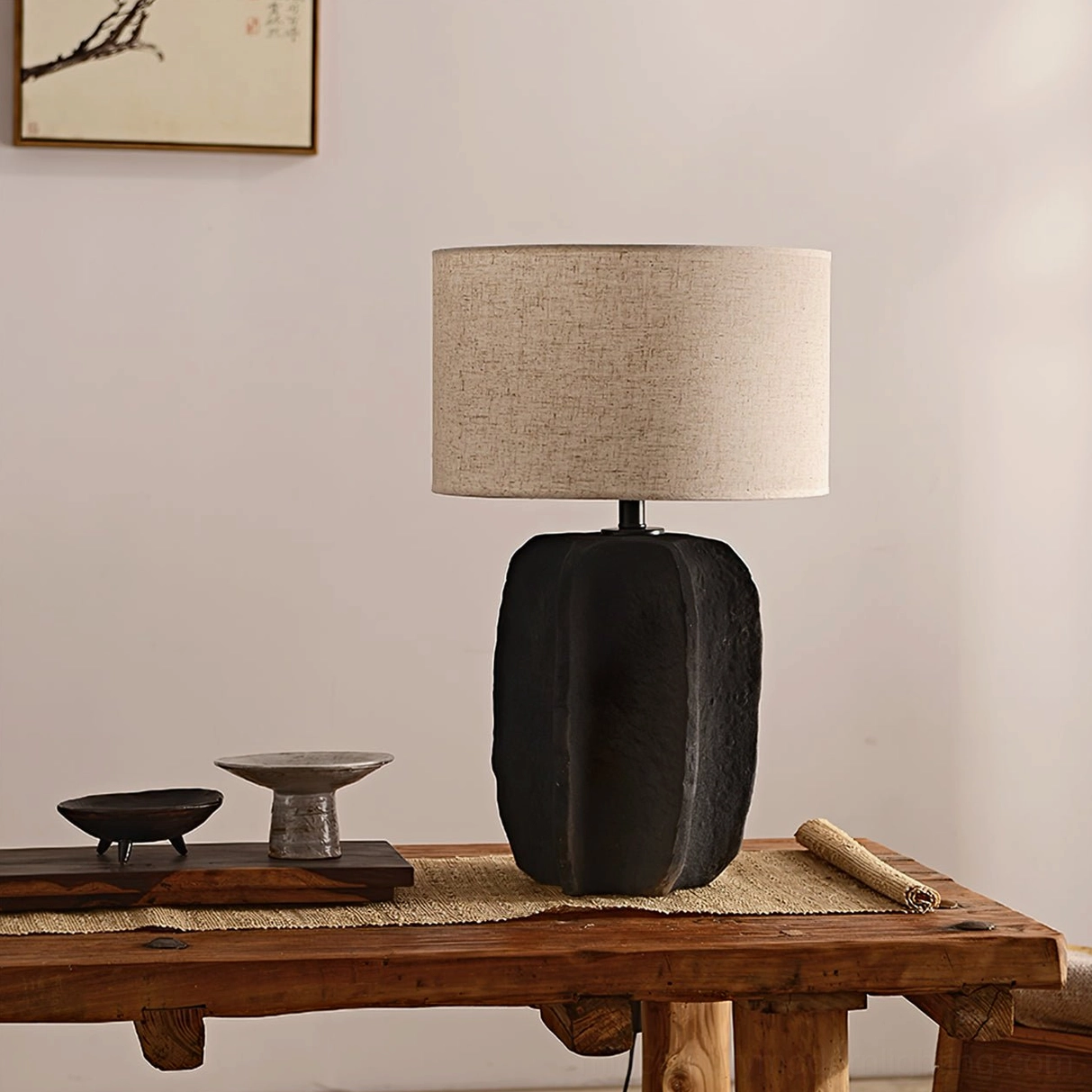 Torso ceramic table lamp with grey linen shade unlit on wooden table surface
