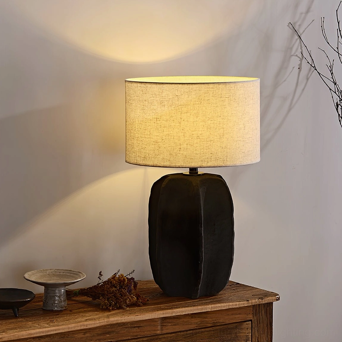 Torso ceramic lamp placed on wooden corner table with dried branches in wabi-sabi interior design