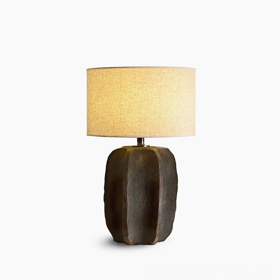 Torso ceramic table lamp with sculptural white base and beige fabric shade on pure white background