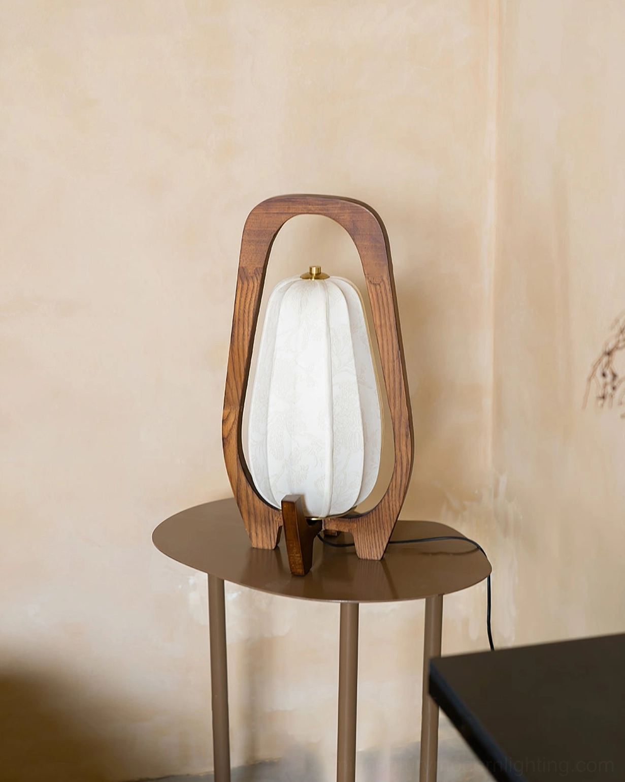 Totem table lamp on round side table near warm neutral wall, rear side angle with power cord visible