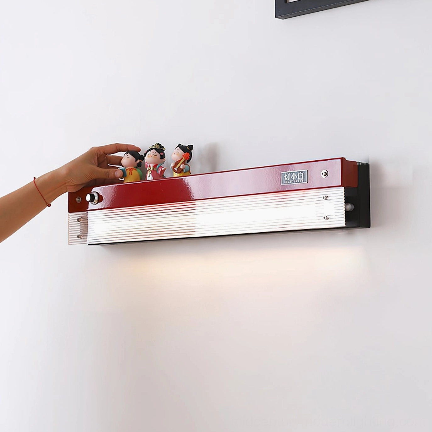 Close-up detail of Totem wall lamp shelf with ribbed acrylic shade and collectible figurines