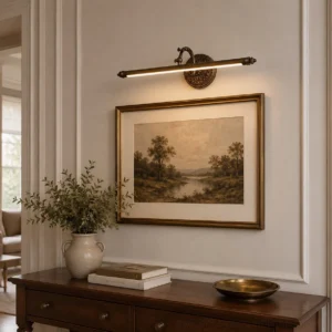 Brass wall picture light with ornate circular backplate mounted in traditional living room above decorative console