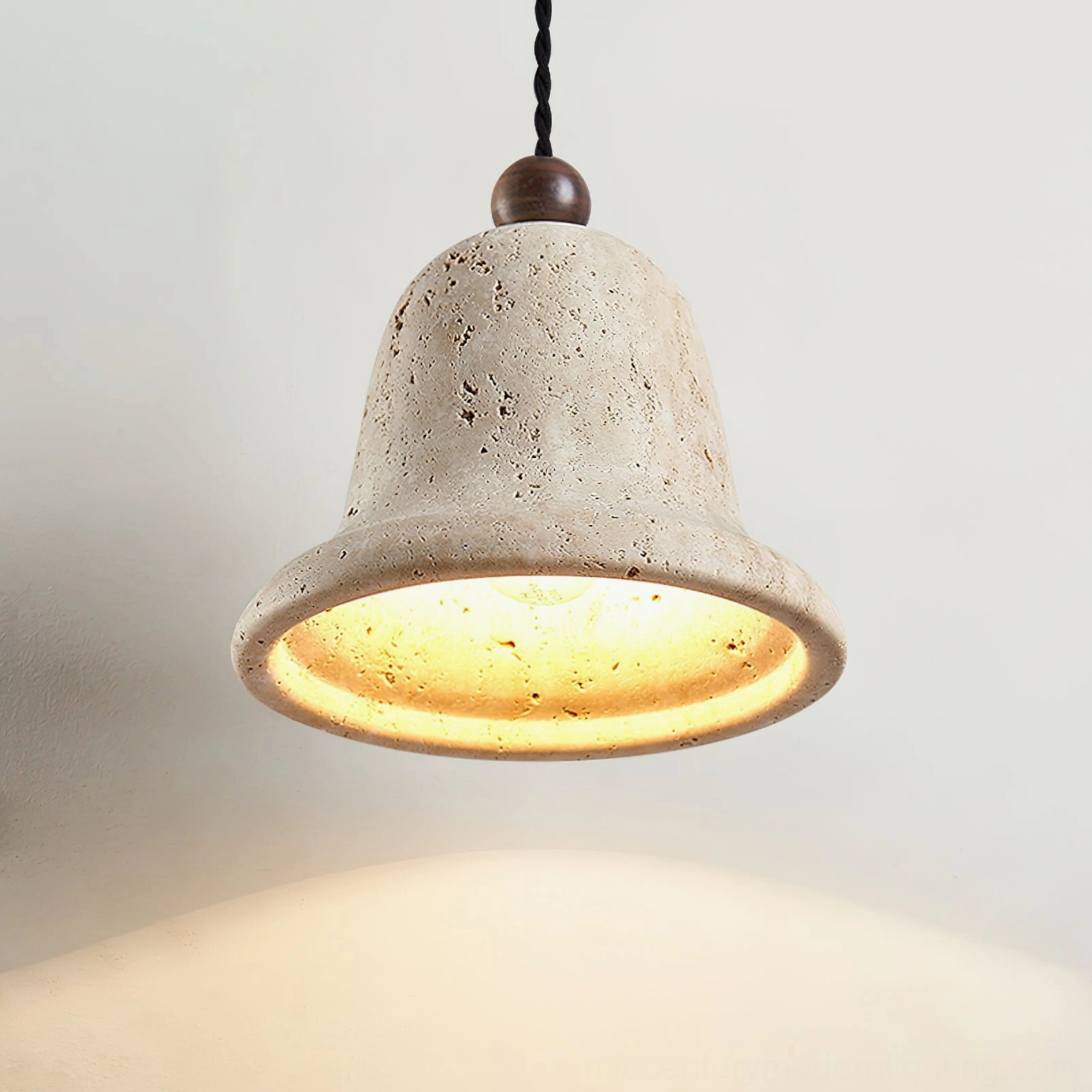 Travertine bell pendant underside view revealing interior glowing light diffusion properties