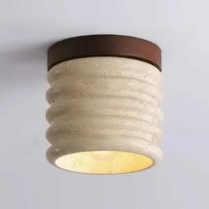 Close-up detail of travertine ceiling lamp showing ribbed surface texture and dark metal base with warm light glow