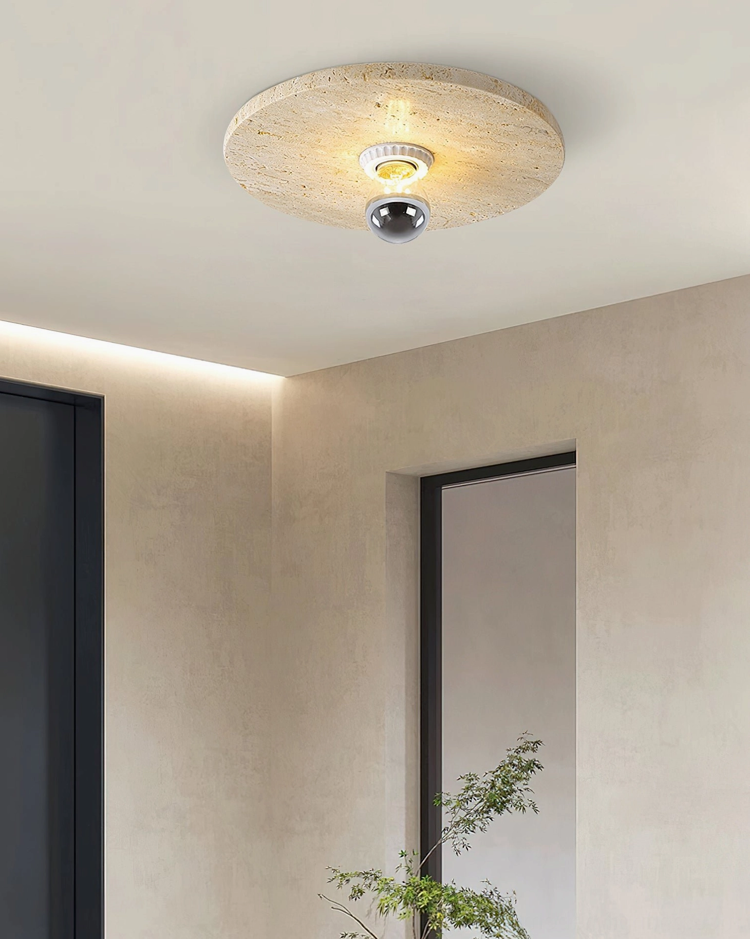 Minimalist residential corner space with travertine ceiling fixture warm ambient lighting and decorative potted greenery