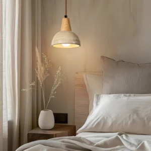 Single travertine pendant light hanging in warm bedroom interior with Japandi rustic styling and beige neutral palette