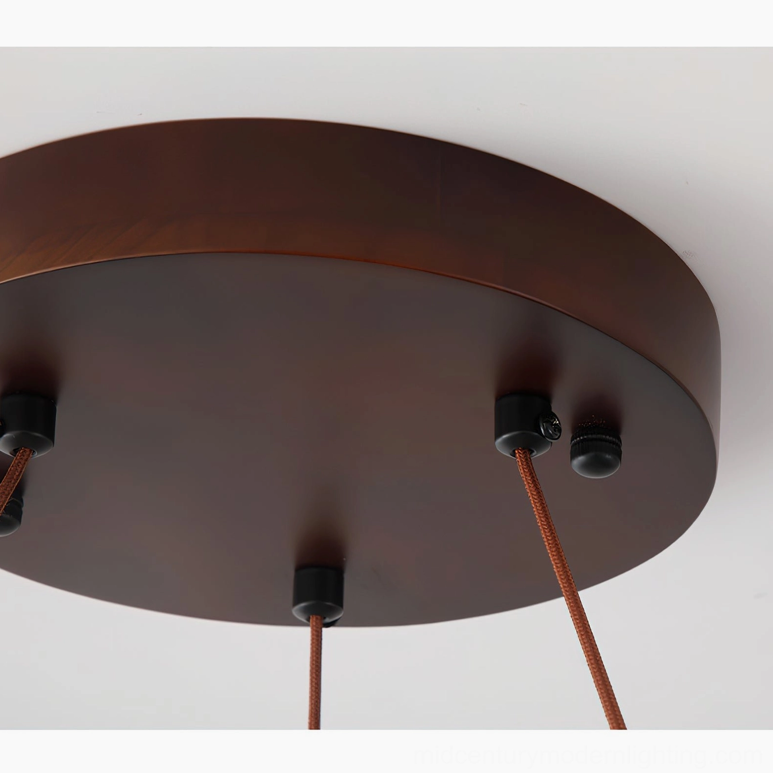 Ceiling mount base of travertine pendant light showing adjustable hanging cord and dark metal bracket assembly