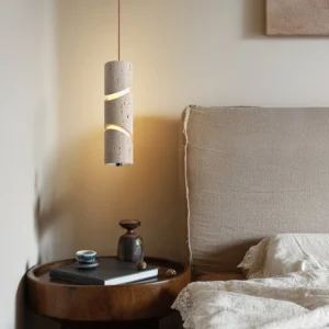 Travertine pendant lamp illuminated in modern bedroom setting, casting warm ambient light and geometric shadows on neutral walls