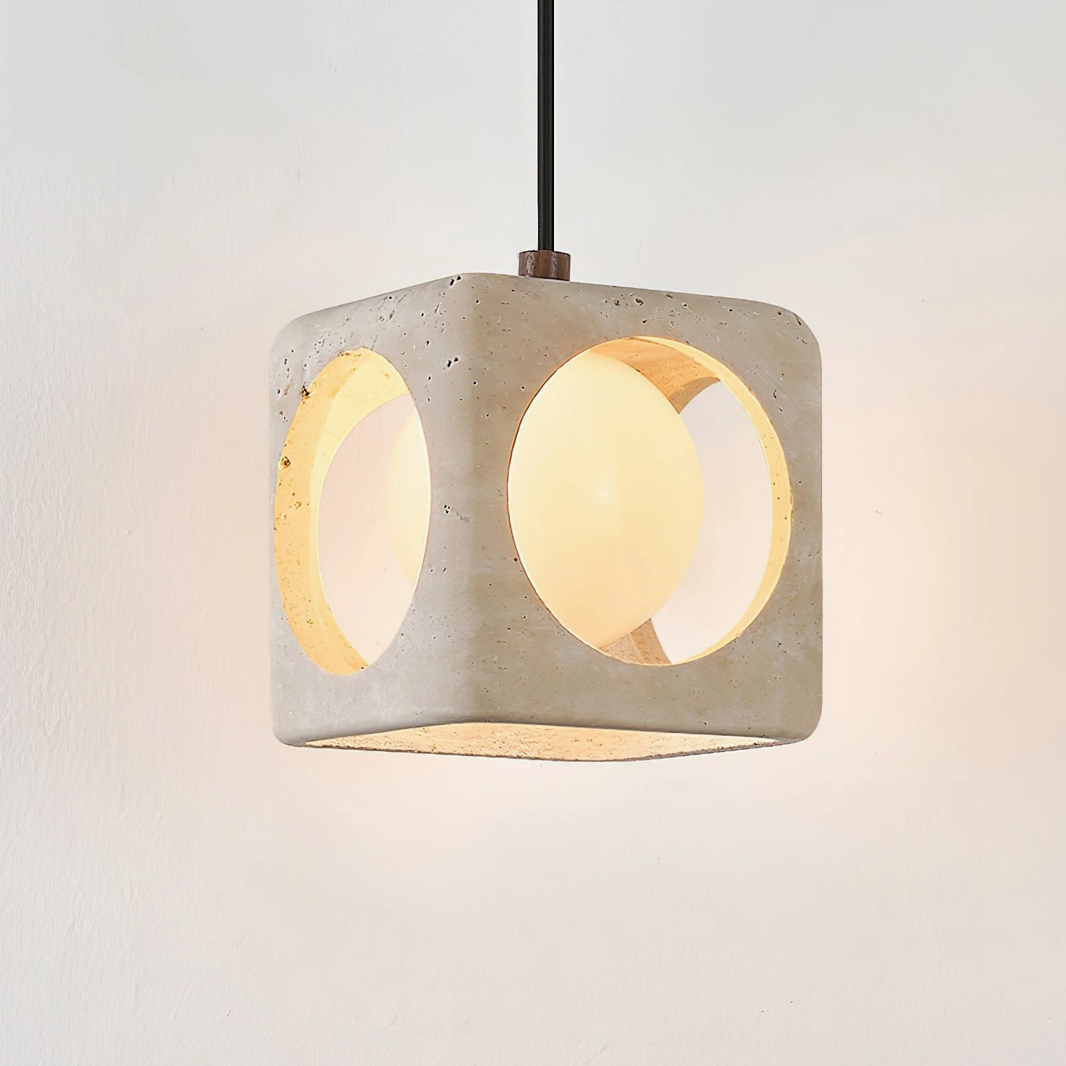 Travertine stone pendant creating soft ambient light and shadow interplay in minimalist modern interior