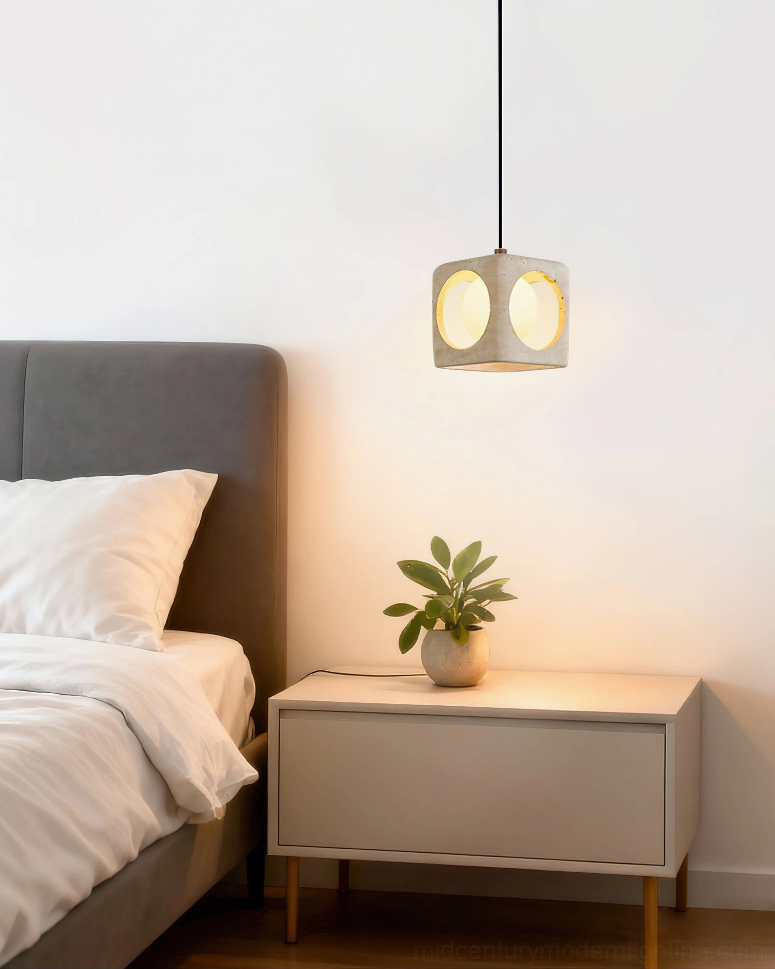 Travertine stone pendant suspended above light wood nightstand with grey fabric headboard, modern bedroom lighting