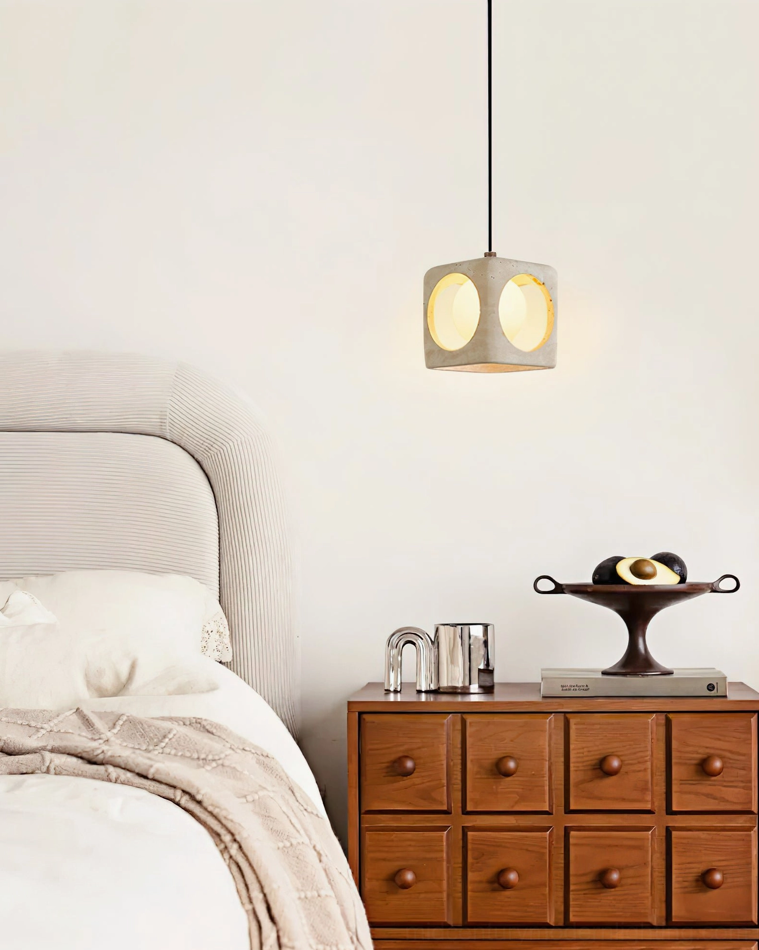 Warm-toned travertine pendant over wooden dresser and bedroom plants, vintage minimalist home decor styling