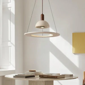 Travertine pendant light suspended over minimalist dining nook with neutral tones and warm lighting