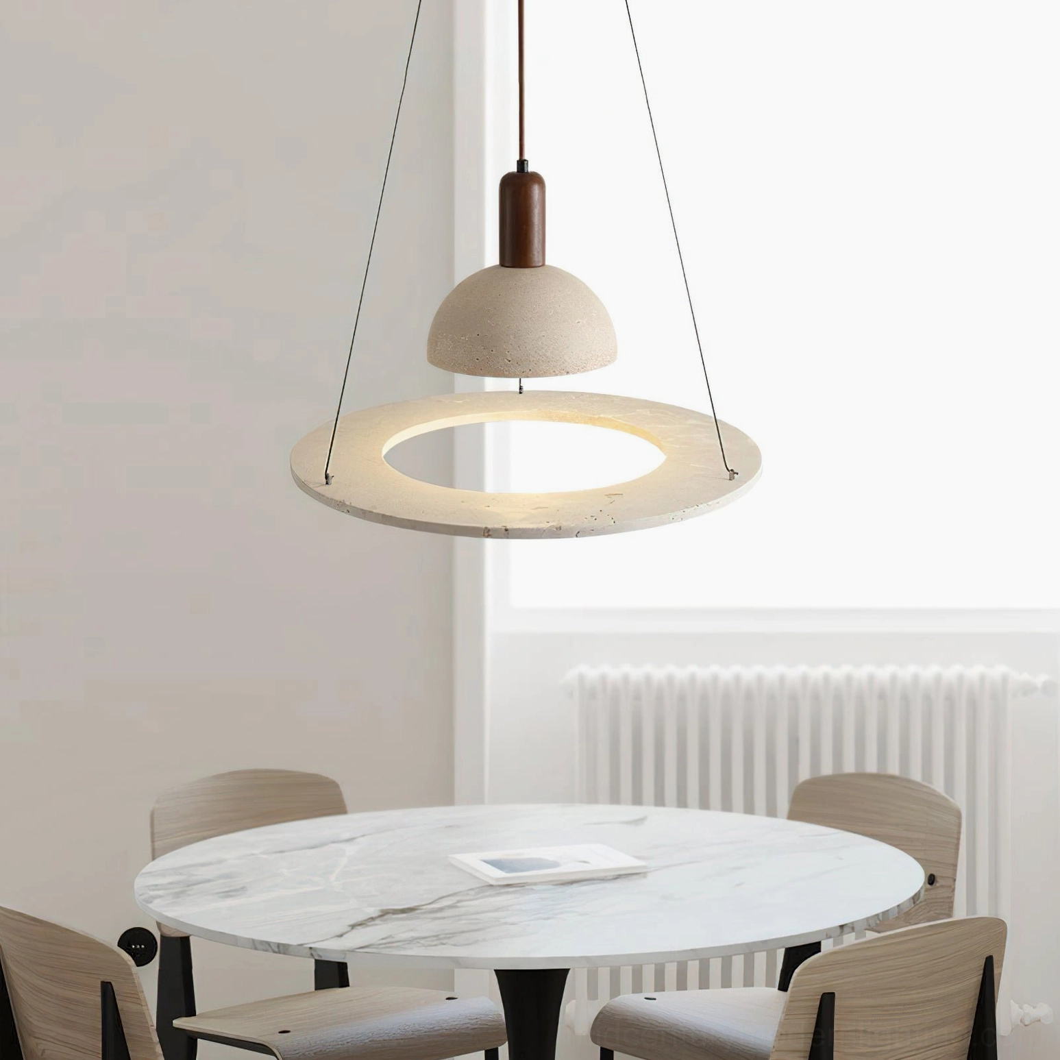 Side view of travertine dome pendant light above marble dining table in wabi-sabi style dining room