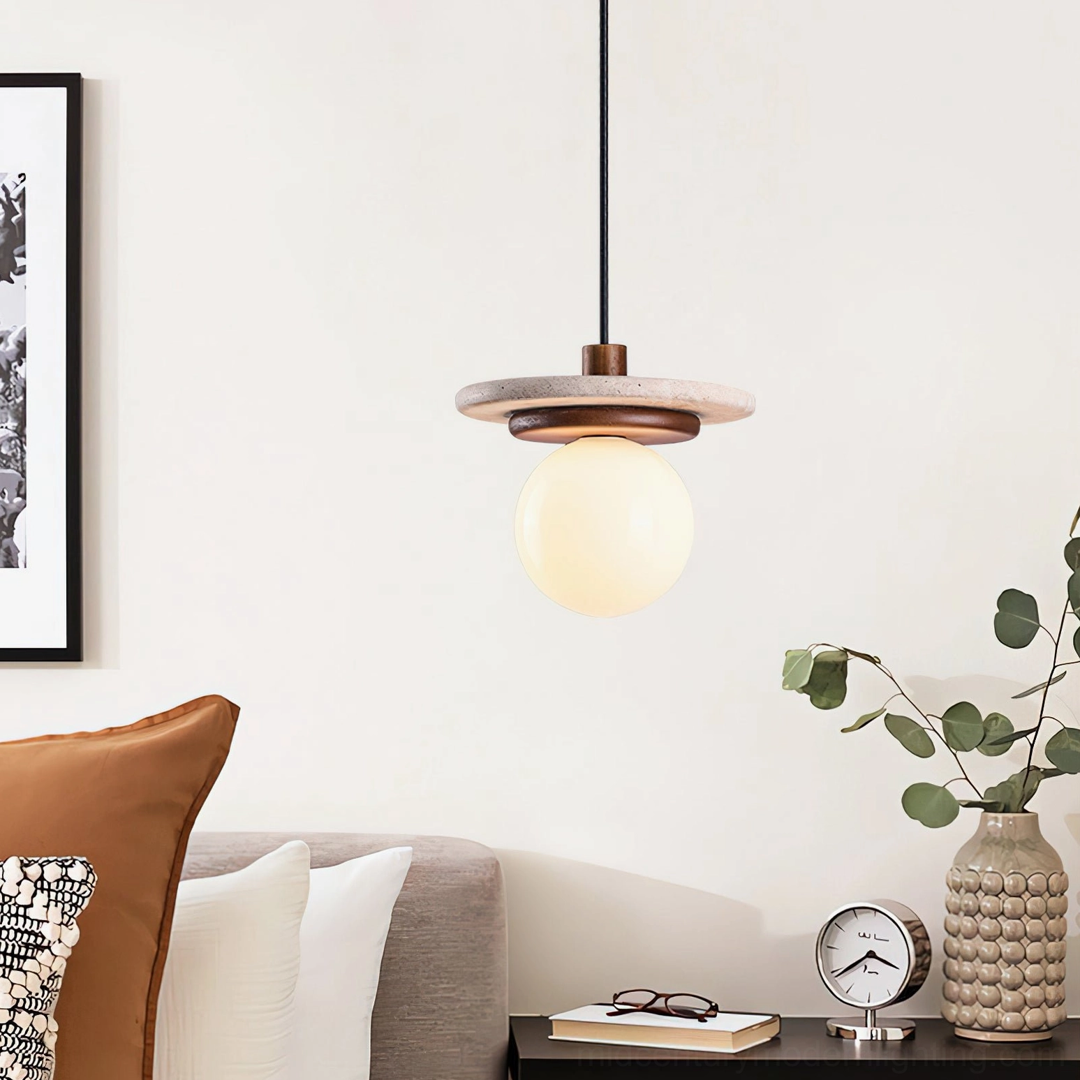 Travertine pendant light installed in warm minimalist living room above sofa with side table and decorative objects