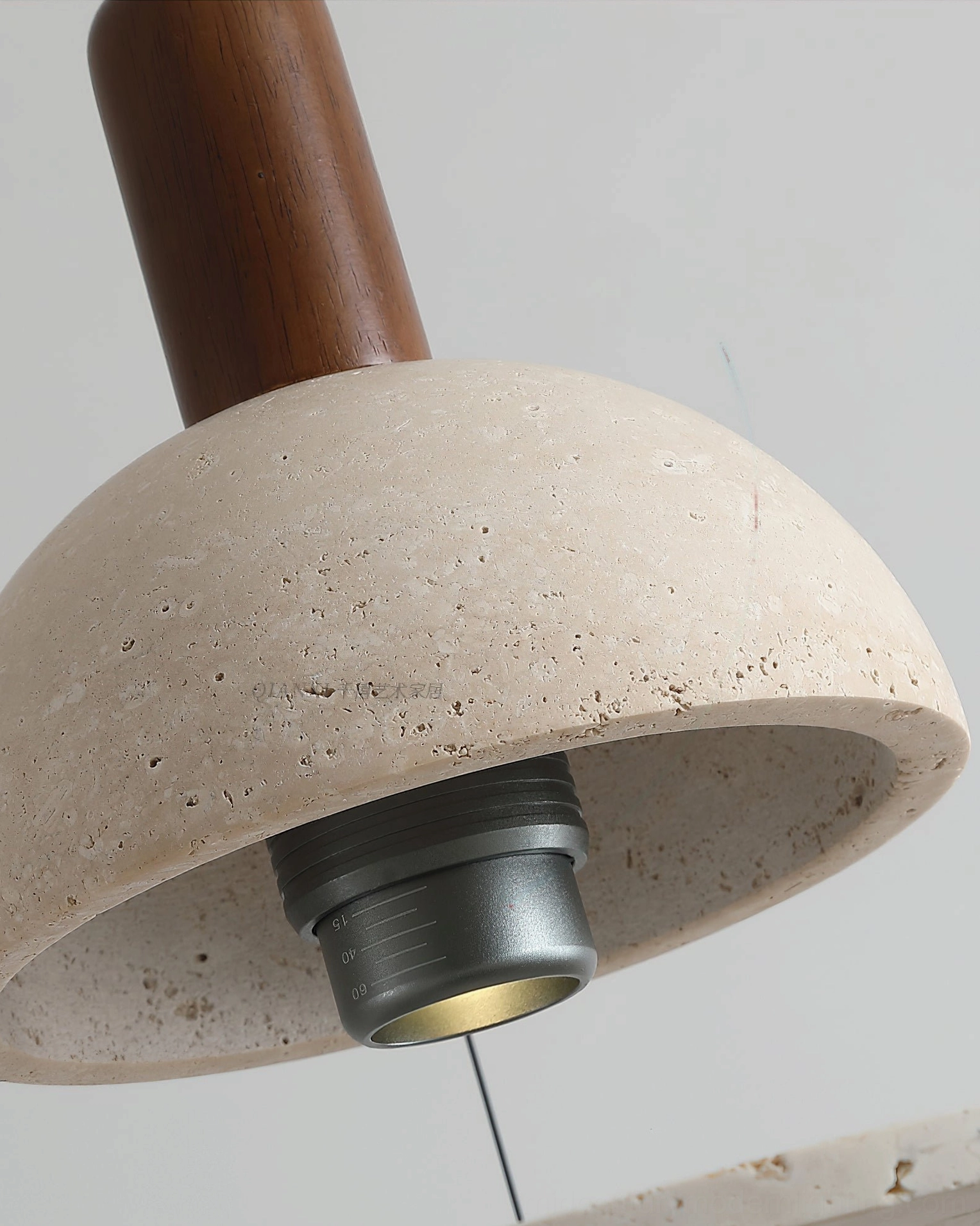 Close-up macro shot of travertine pendant light showing natural stone texture, pitting, and lamp socket details