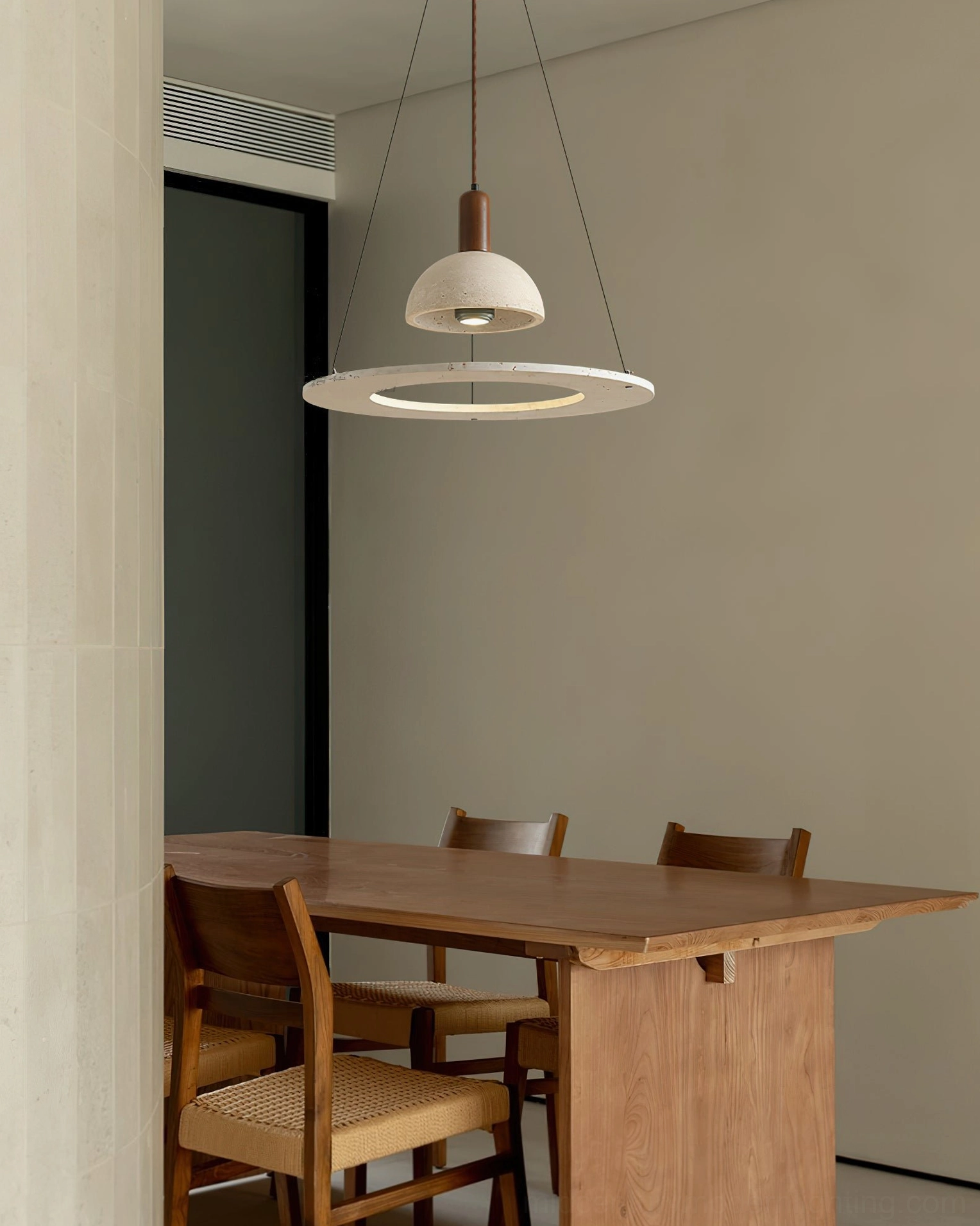 Travertine dome pendant light illuminating wooden long dining table in rustic minimalist interior