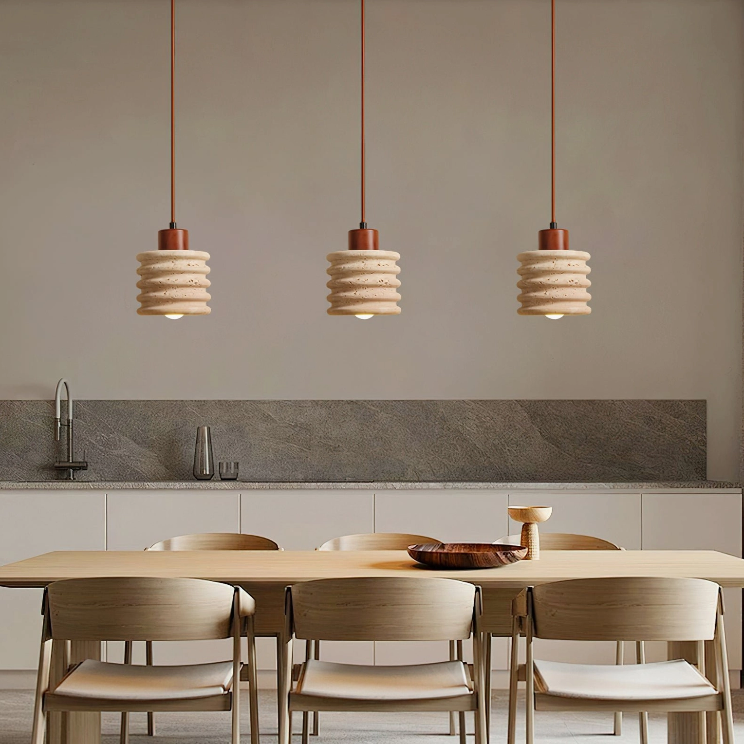 Multiple travertine pendant lights installed in modern kitchen-dining area, uniform neutral wabi-sabi set