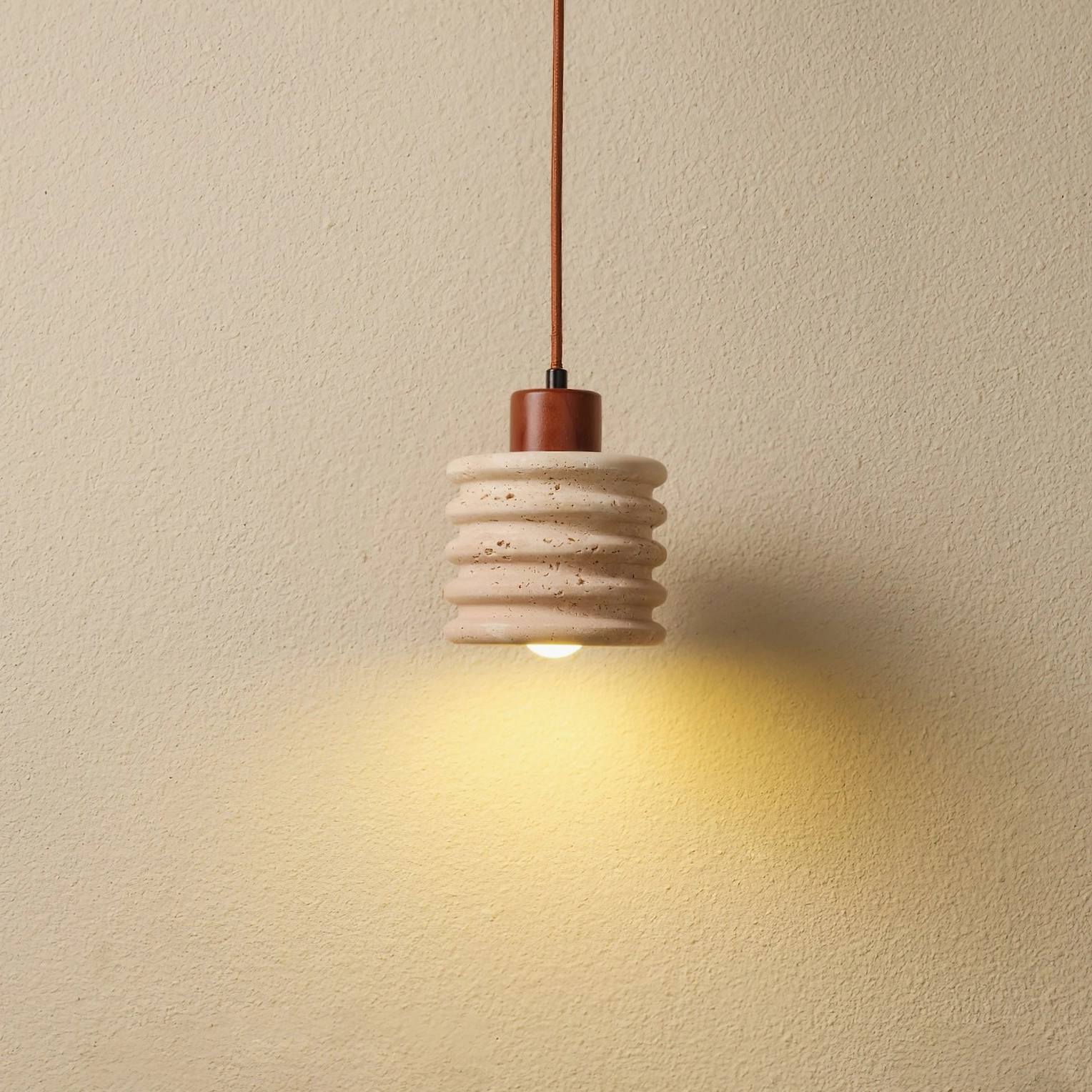 Luces pendant light hanging in studio setting casting warm downlight with minimalist design