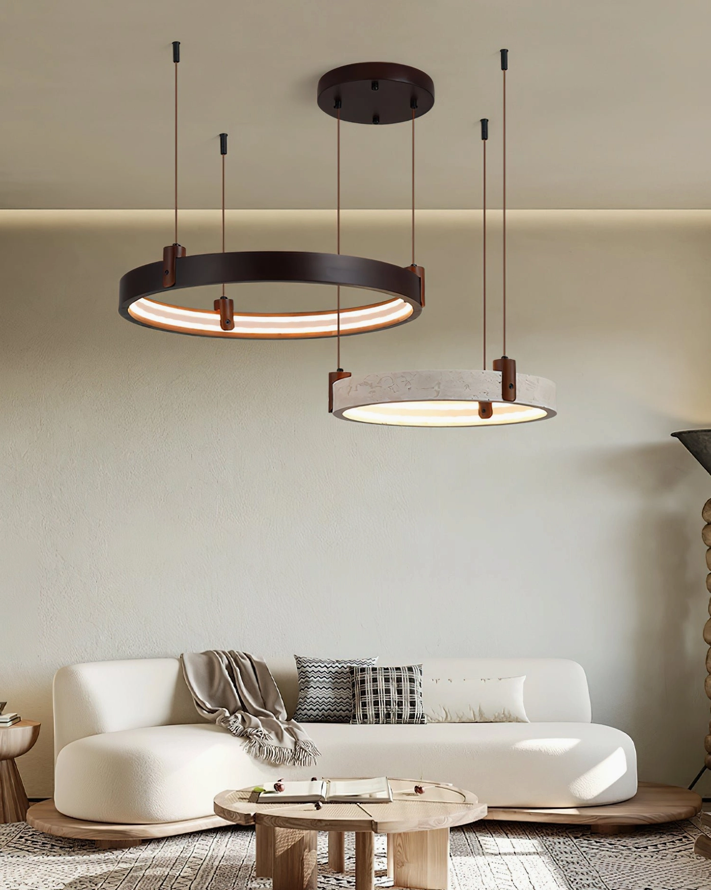 Close-up view of dual circular travertine pendant rings with warm integrated LED illumination in minimalist low-profile living space