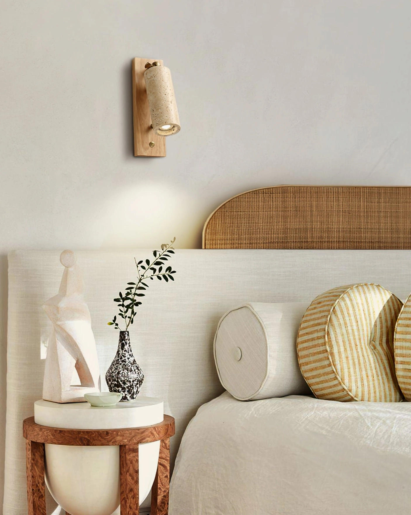 Travertine sconce wall-mounted in boho bedroom with upholstered headboard and oak wood backplate