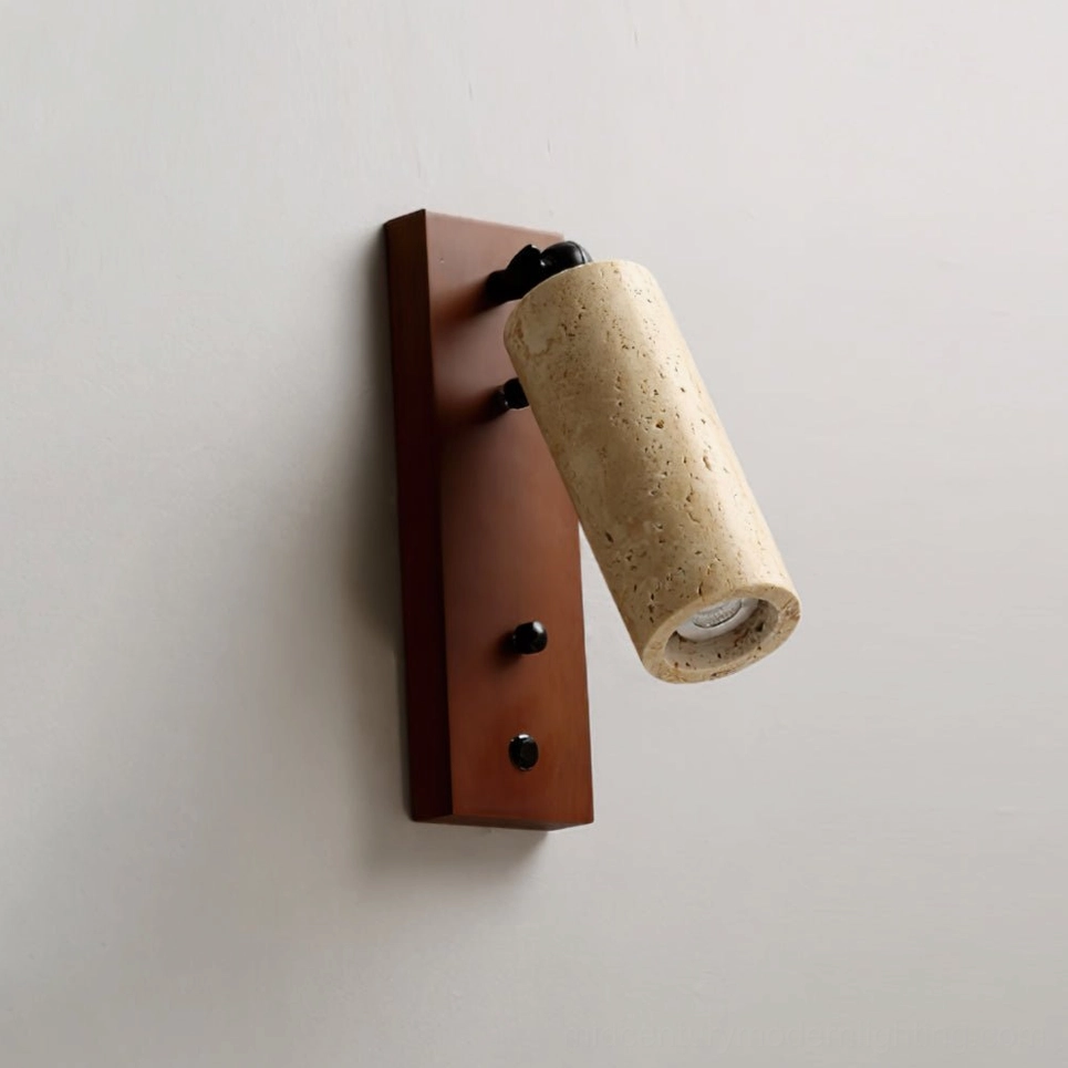 Three-quarter side close-up of travertine wall sconce showing dark brown backplate, brass fixtures, and adjustable shade