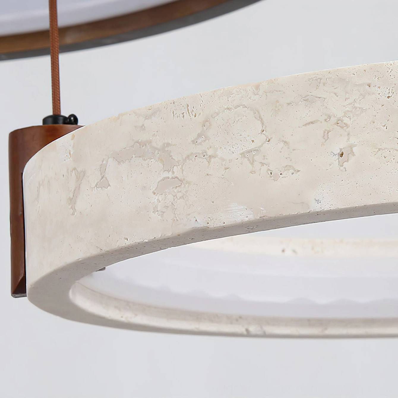 Modern travertine ring chandelier detail shot showing natural stone veining and integrated LED illumination quality
