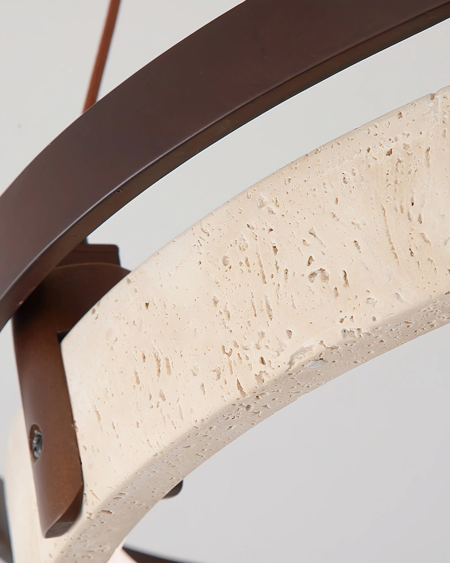 Travertine pendant light close-up showing porous stone texture and dark metal frame detail against white background