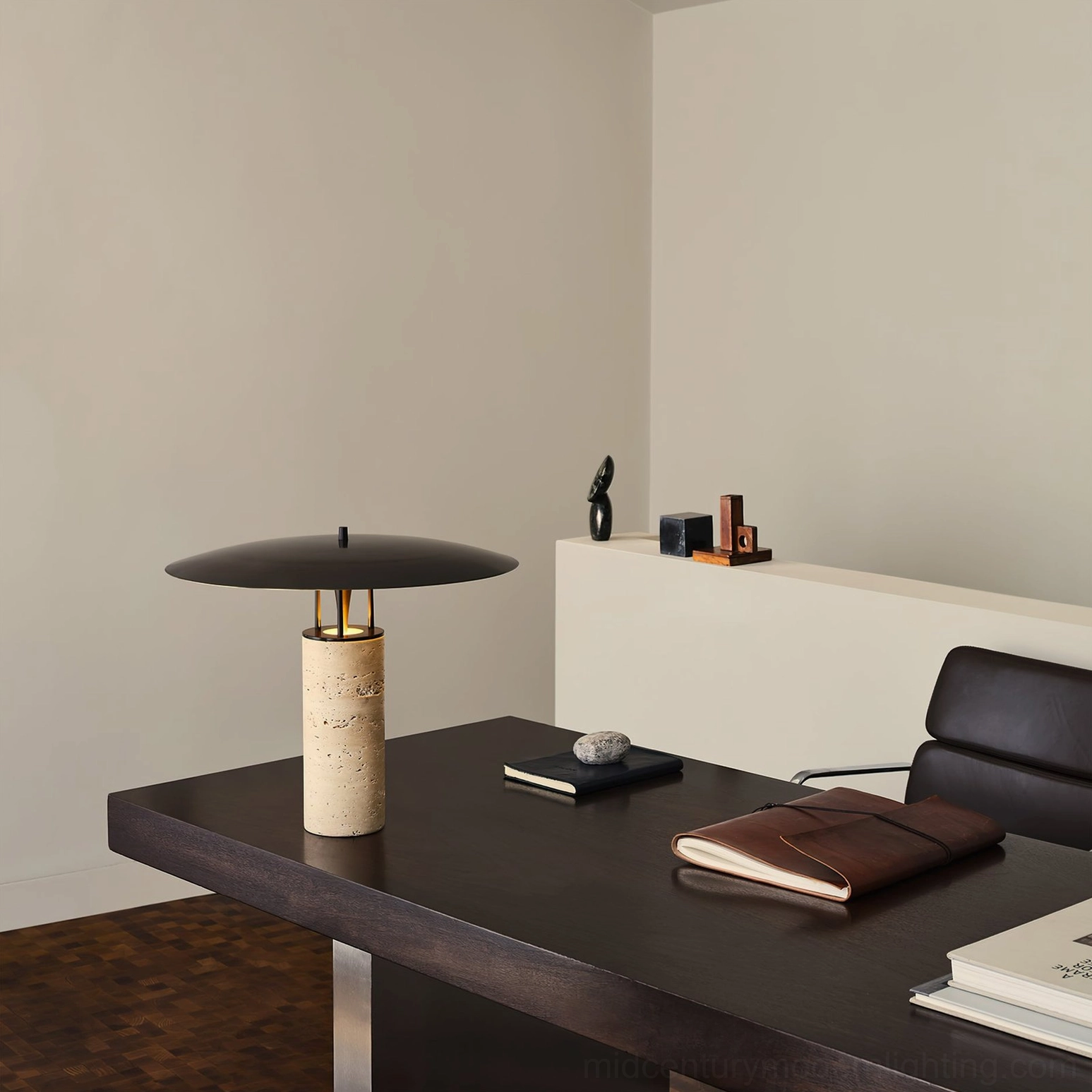Travertine table lamp on dark wood home office desk with leather notebook, contemporary workspace lighting