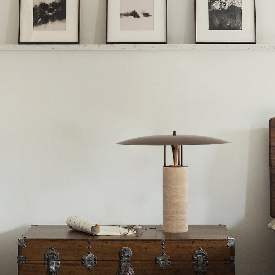 Travertine table lamp positioned on vintage storage trunk with framed artwork wall display, eclectic interior styling