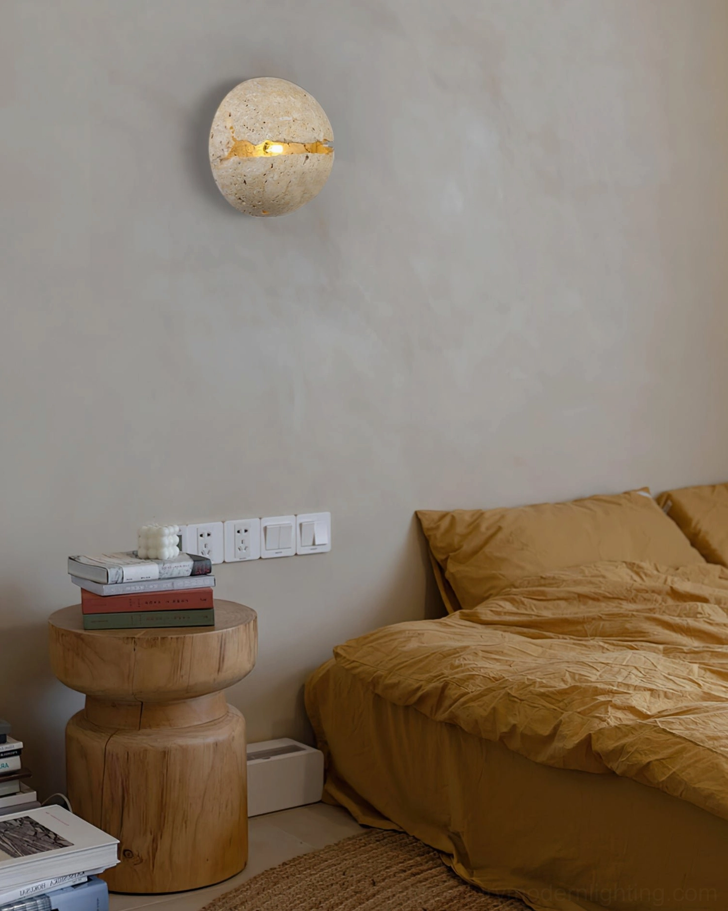 Single illuminated round travertine wall lamp in minimalist bedroom creating soft ambient glow