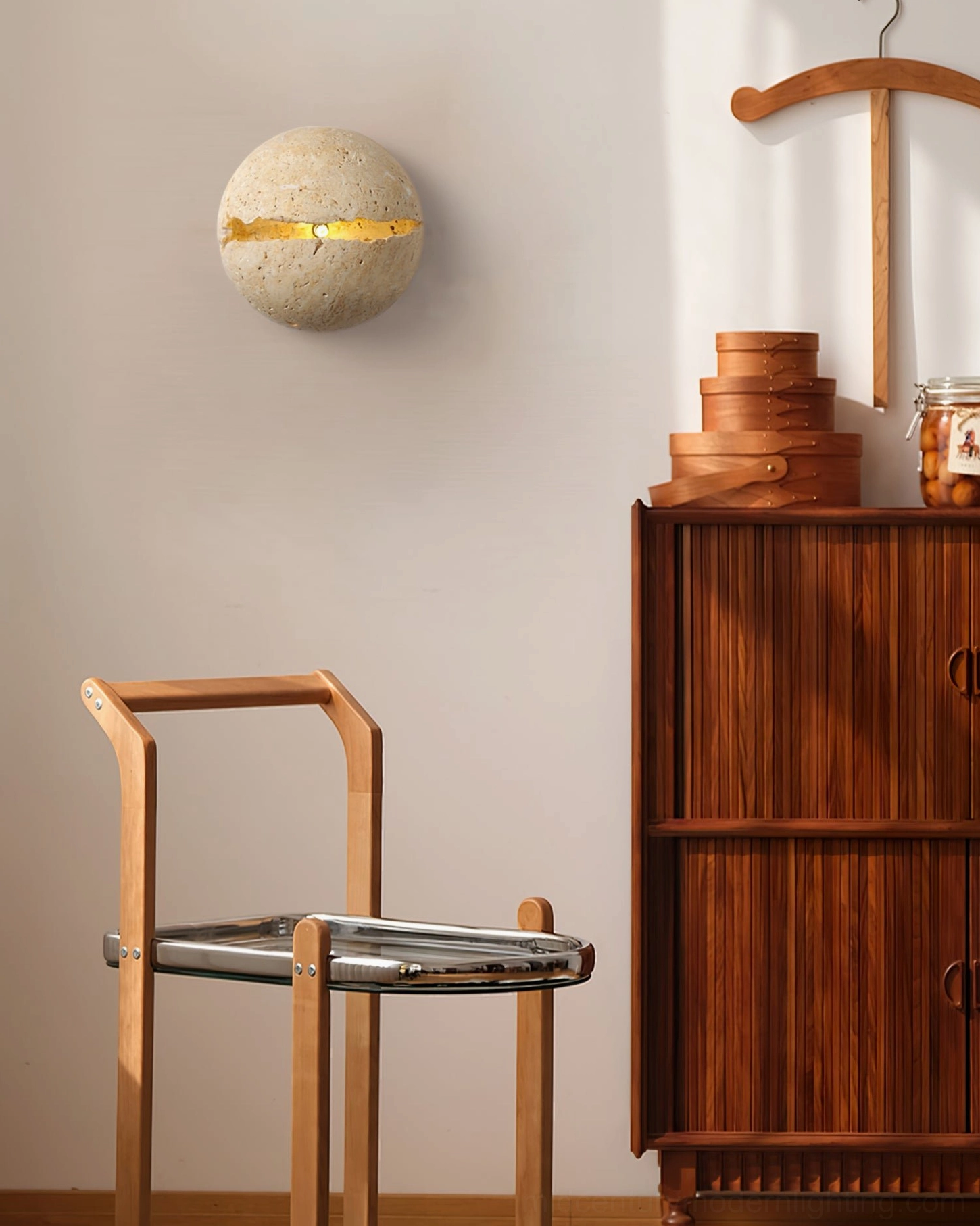 Single round travertine wall lamp installed in warm Japandi dining corner with wooden furniture