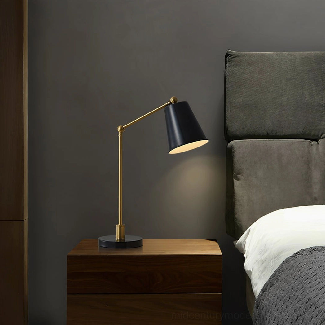 Tresa modern brass table lamp side profile view in bedroom setting with upholstered headboard