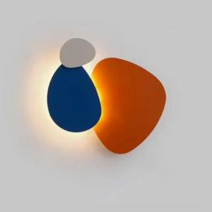 Tria wall light cluster in burnt orange and navy blue LED modules with backlit glow on white indoor wall