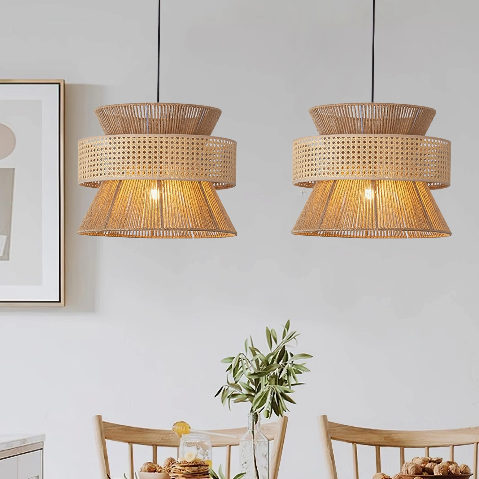 Dual matching tiered rattan pendant lamps installed over minimalist dining area with wall artwork