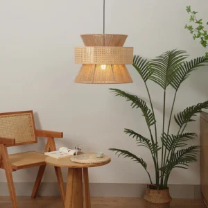 Three-tier rattan pendant light installed in bohemian dining room with natural textiles and potted palm plants