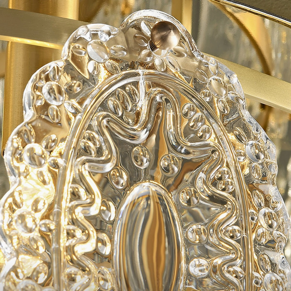 Macro close-up of single Trillion crystal pendant showing intricate carved texture and light-reflective surface