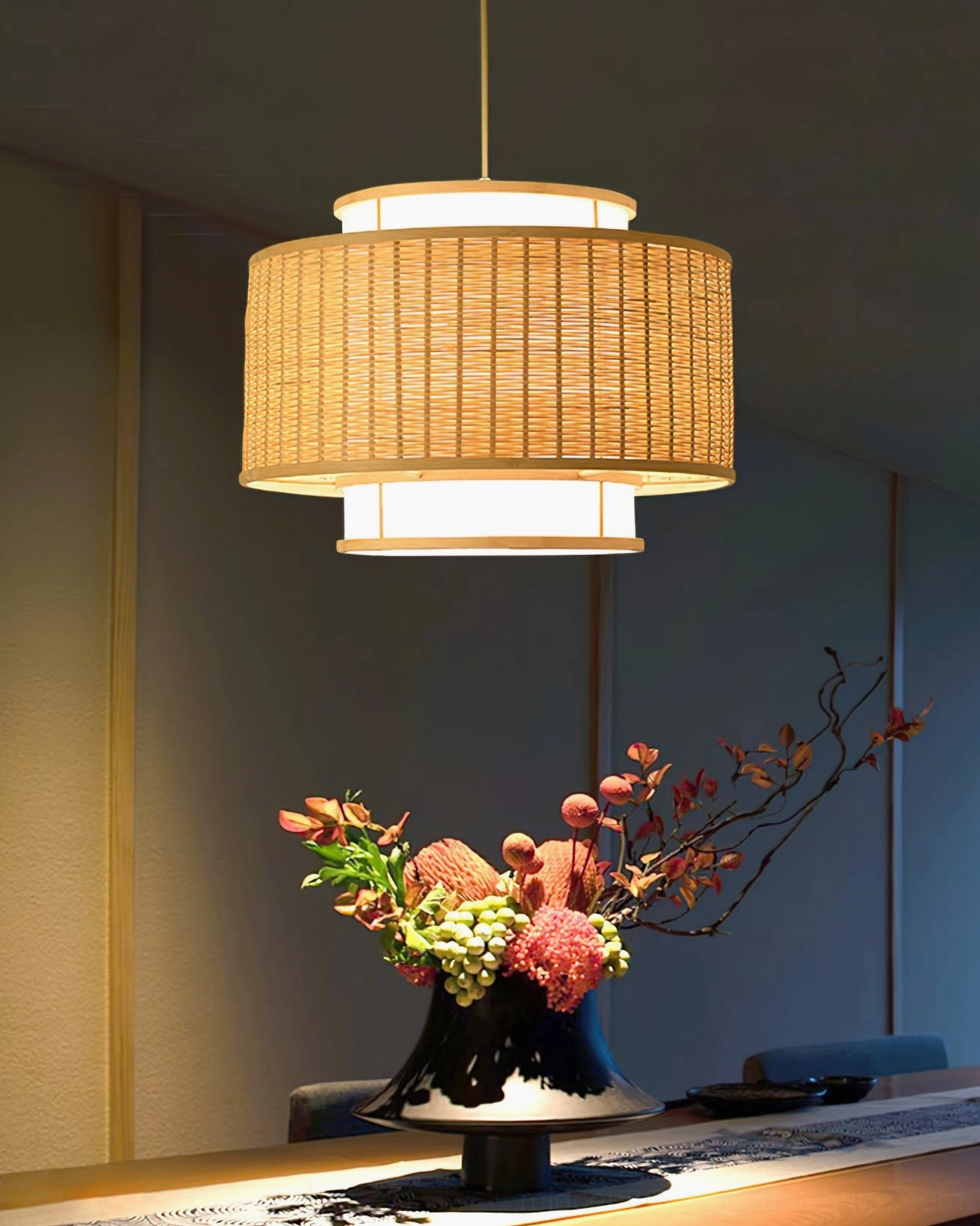 Trinidad rattan pendant lamp in minimalist dining room with black ceramic flower vase centerpiece