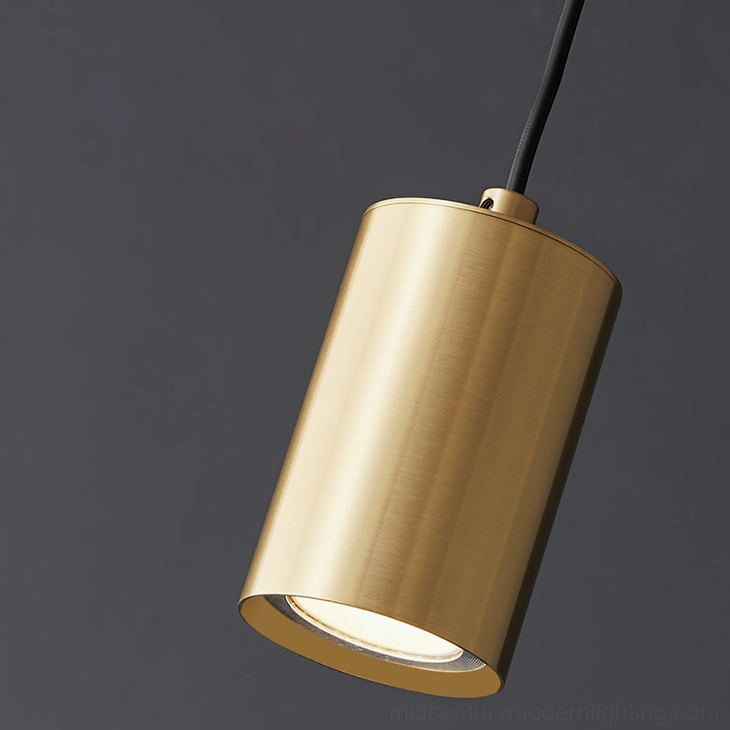 Close-up low-angle view of brushed brass trio pendant lamp - exposed light detail studio shot