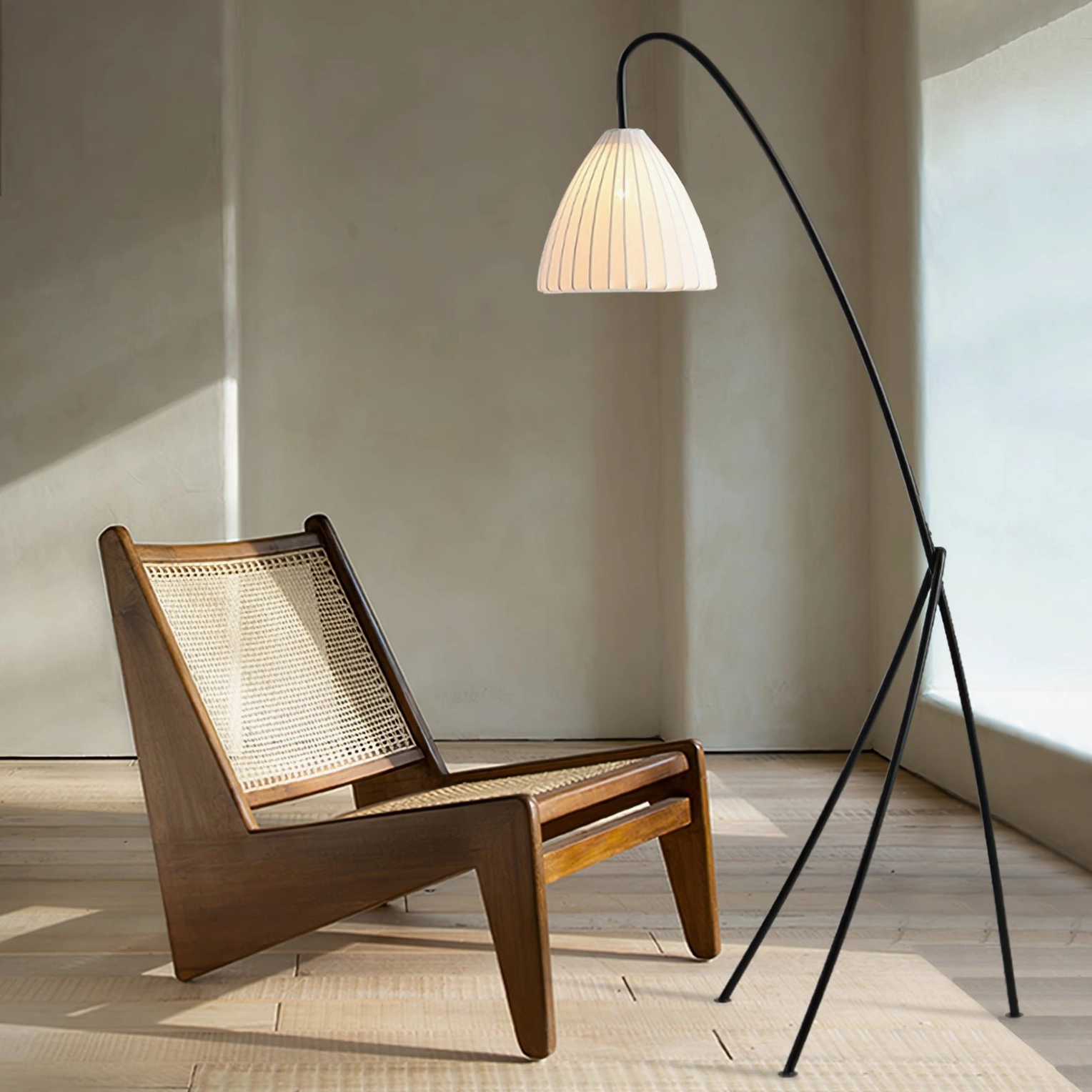 Matte black tripod floor lamp in minimalist wooden living room, eye-level perspective showcasing mid-century modern style and warm ambient lighting