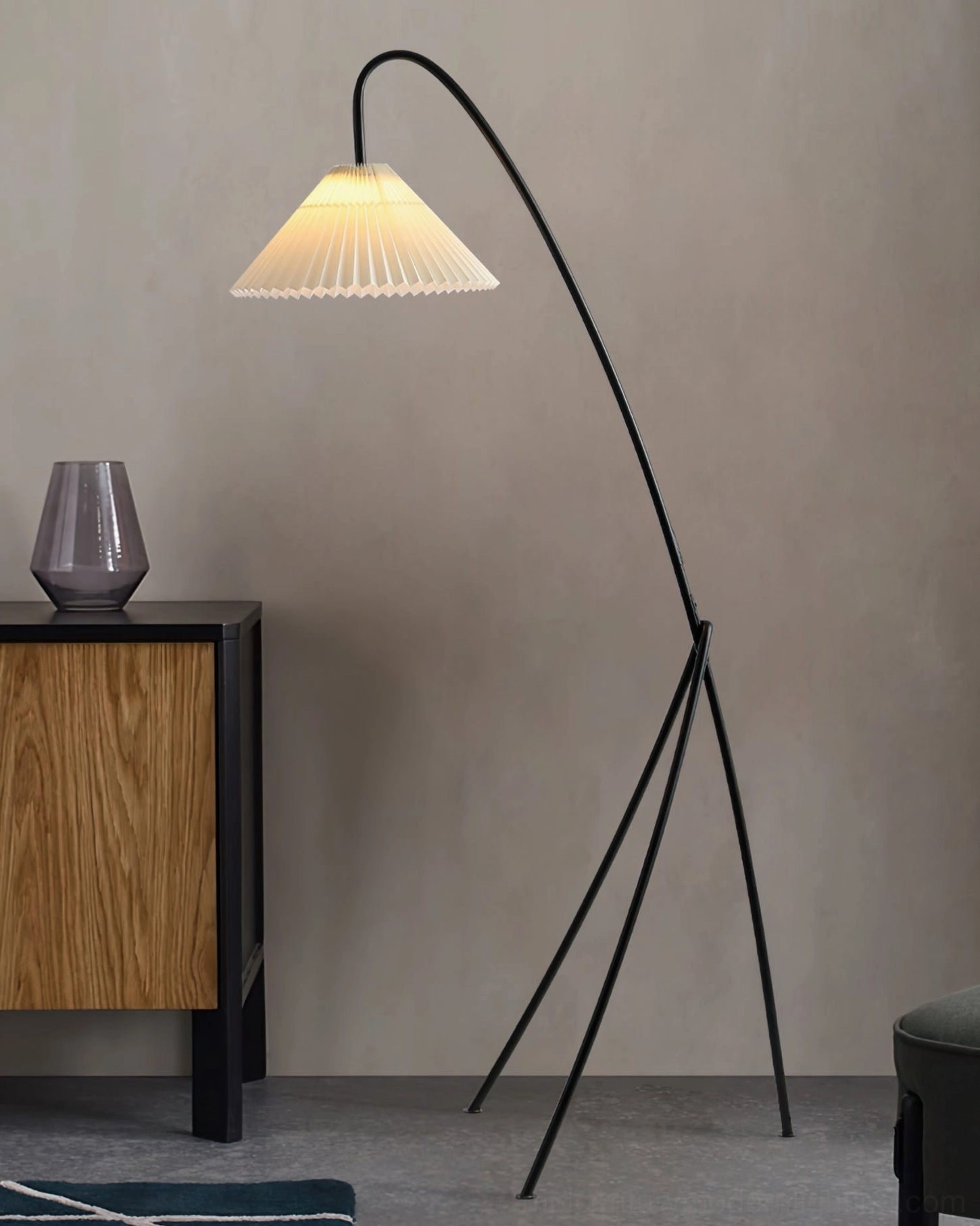 Modern arc tripod floor lamp in contemporary entryway with side cabinet, sleek minimalist design accent piece in side-angle shot