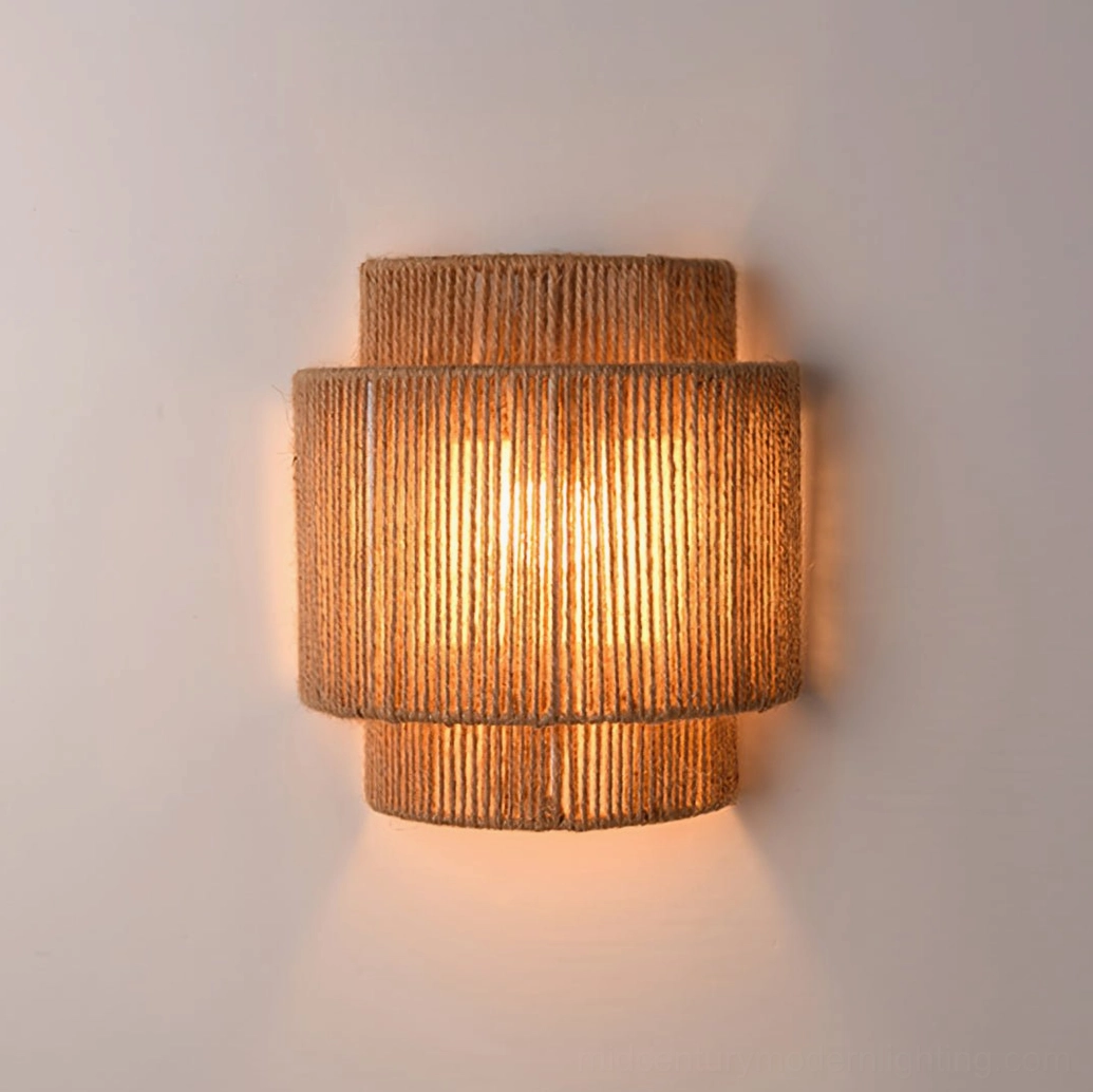 Illuminated tiered rope wall lamp with soft warm glow, frontal view on light background