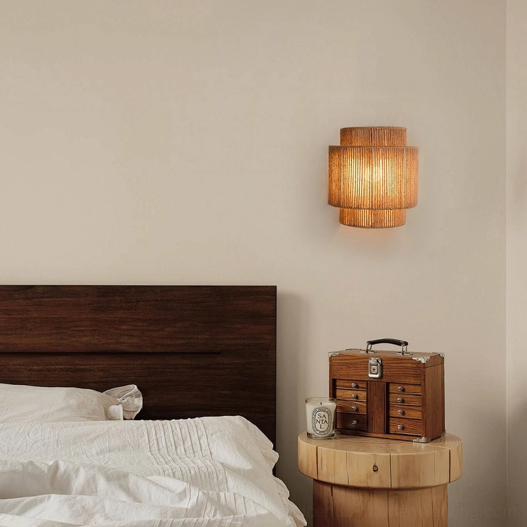 Lit Tristan tiered rope sconce casting warm ambient light in bedroom, dark wood headboard accent