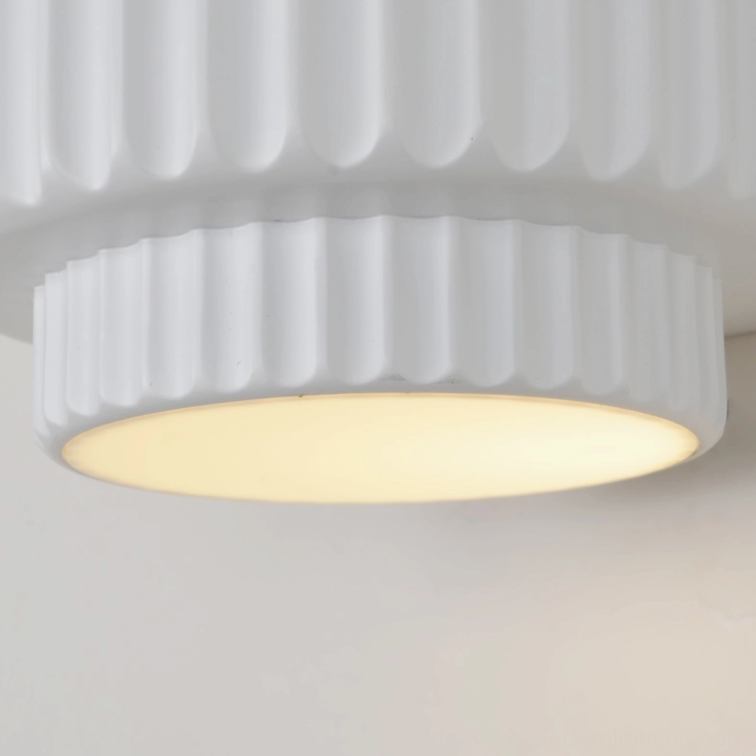 Tristan wall lamp close-up showing warm ambient glow with smooth matte ribbed architectural frame