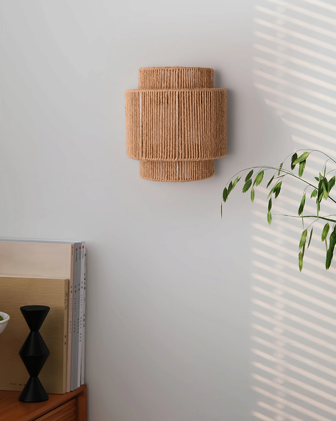 Woven jute rope wall lamp installed in bedroom corner with plant and bohemian decor, wabi-sabi style