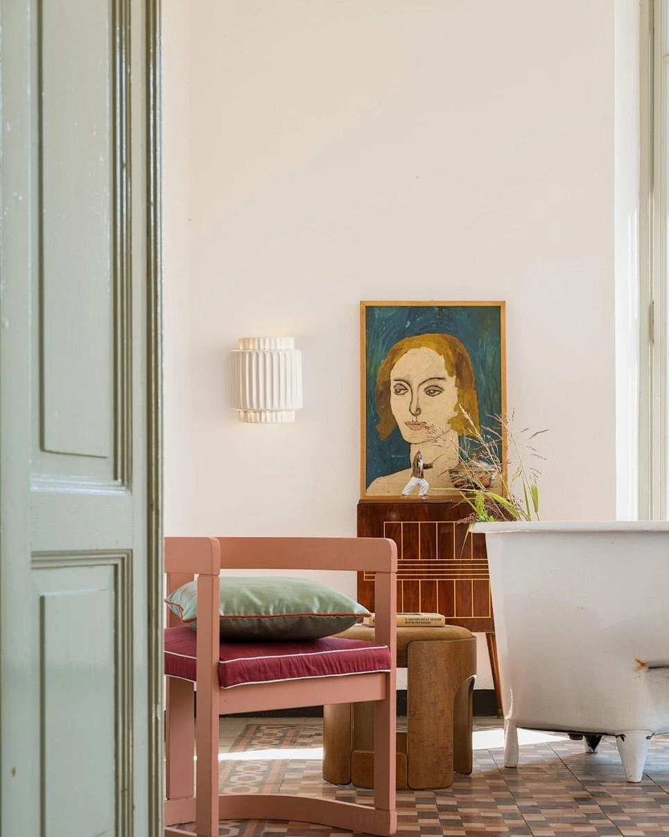 Tristan mid-century modern wall lamp creating ambient lighting in contemporary minimalist bedroom space