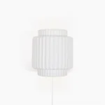 Tristan modern plug-in wall sconce with ribbed cylindrical design and matte white finish, front view on white background