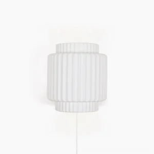 Tristan modern plug-in wall sconce with ribbed cylindrical design and matte white finish, front view on white background