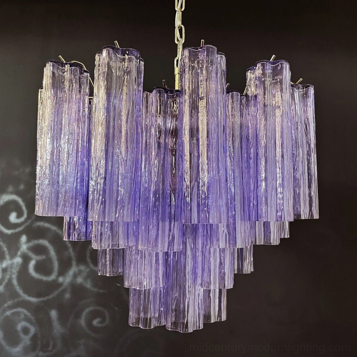 Contemporary cascading glass tube chandelier with warm ambient illumination in residential setting