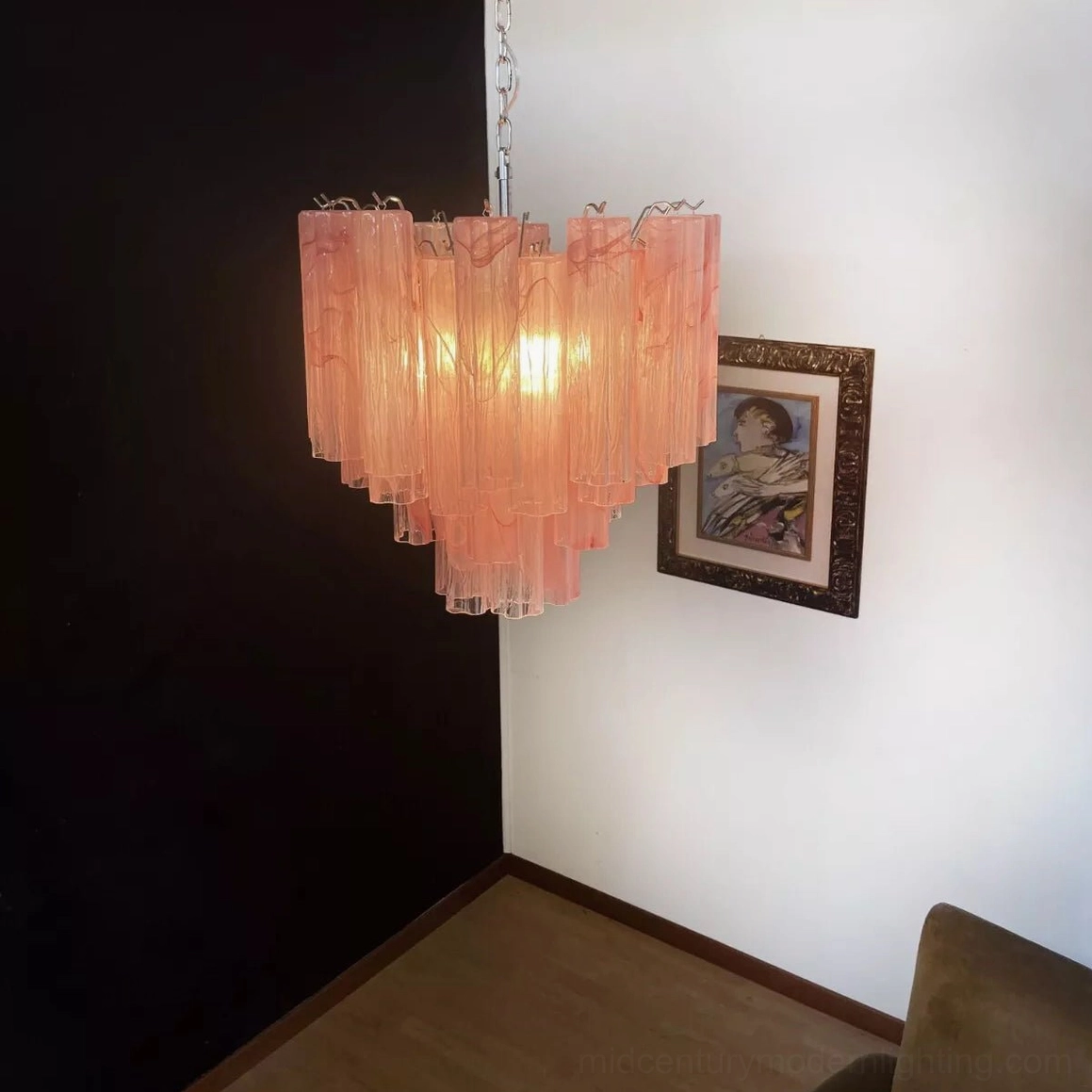 Tronchi pink glass chandelier in furnished modern living room, warm illuminated display showing interior design application