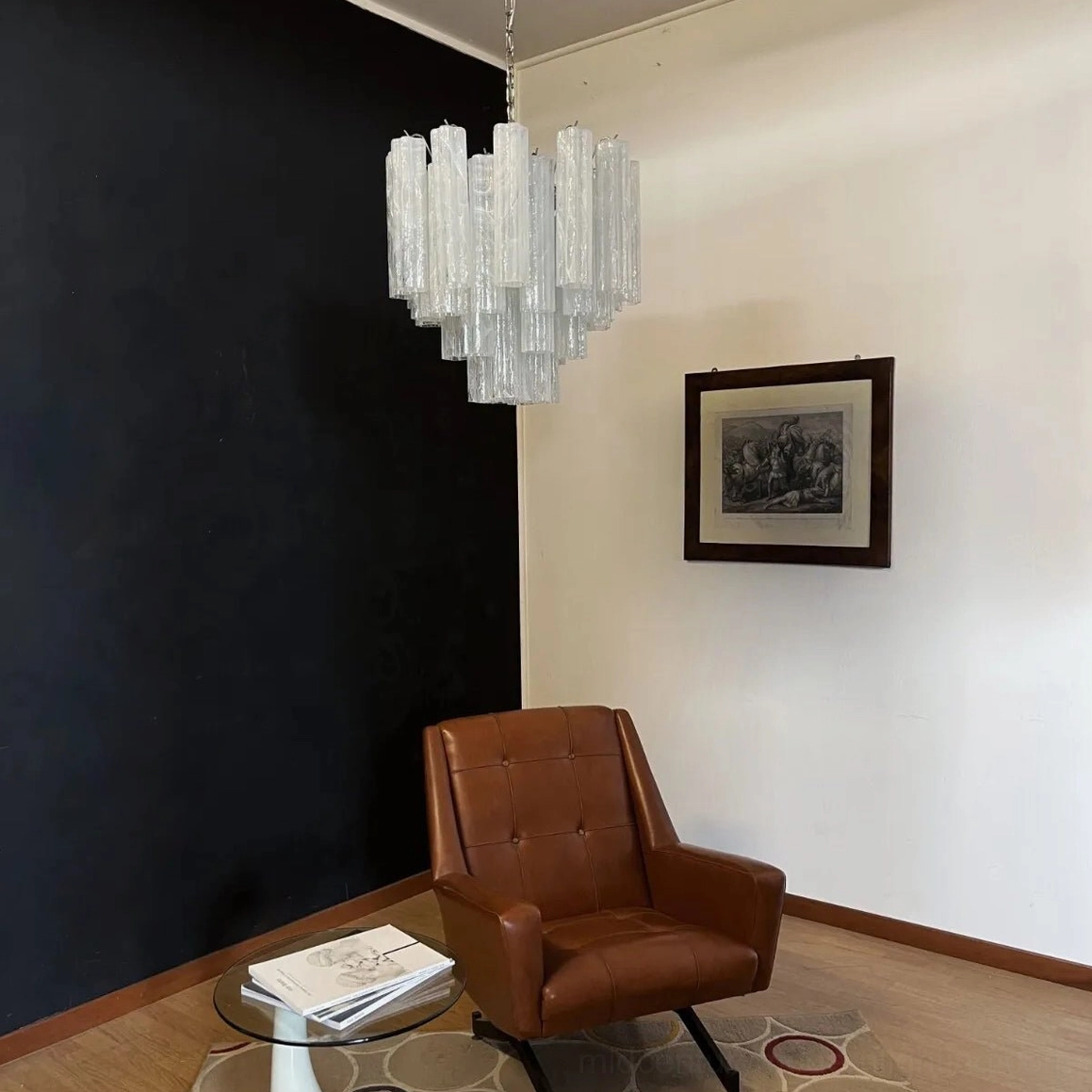 White tiered glass chandelier hanging in minimalist residential living room, neutral contemporary home decor setting